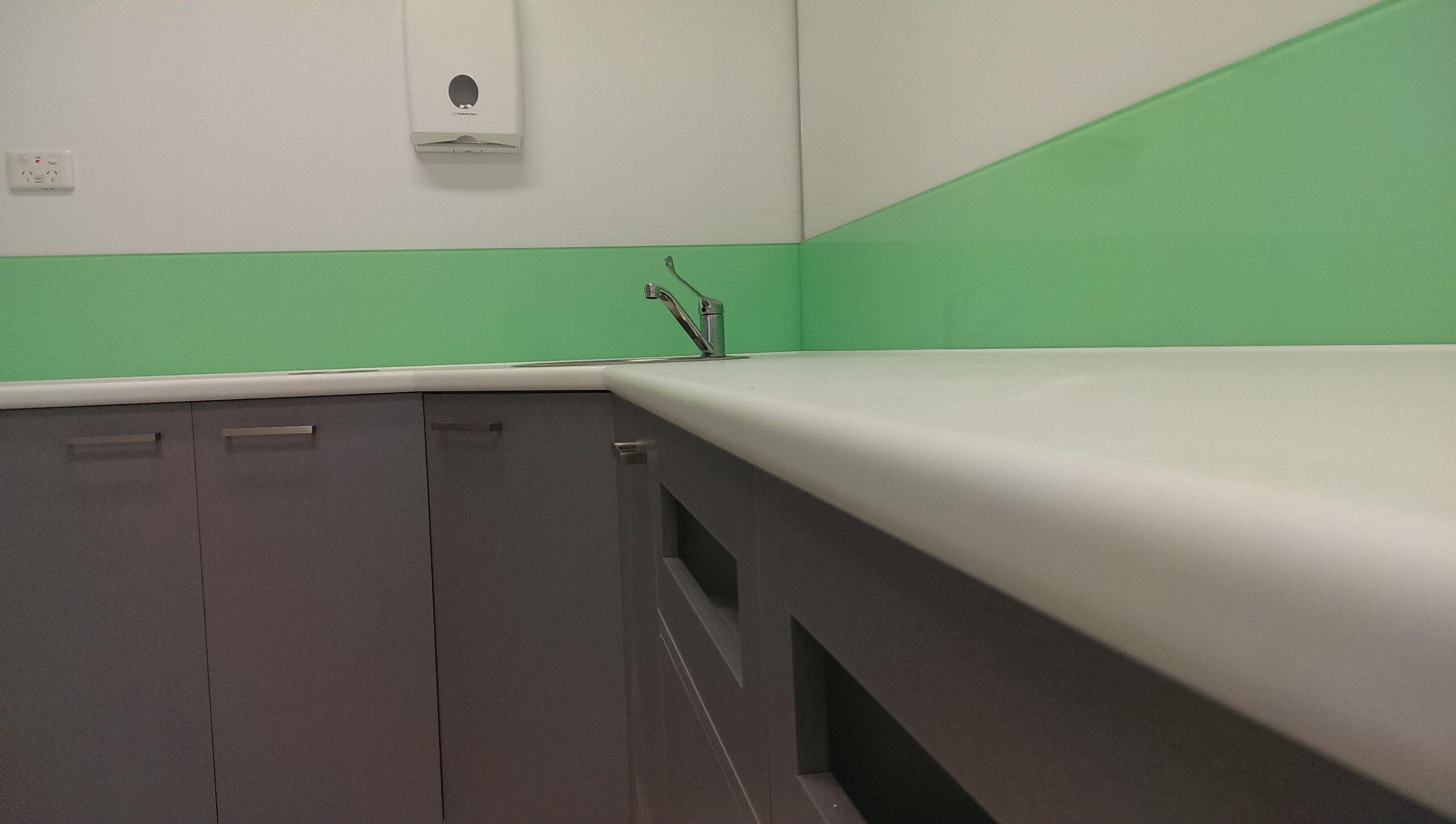 Custom dental cabinetry with a green splashback